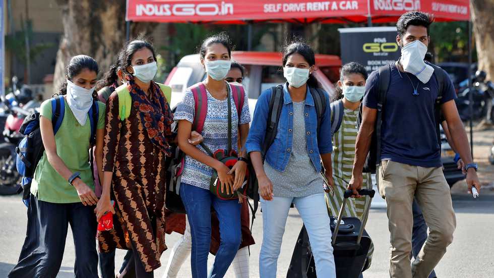 A group of students wearing protective masks walk outside a railway station amid coronavirus fears, in Kochi, India, March 10, 2020.