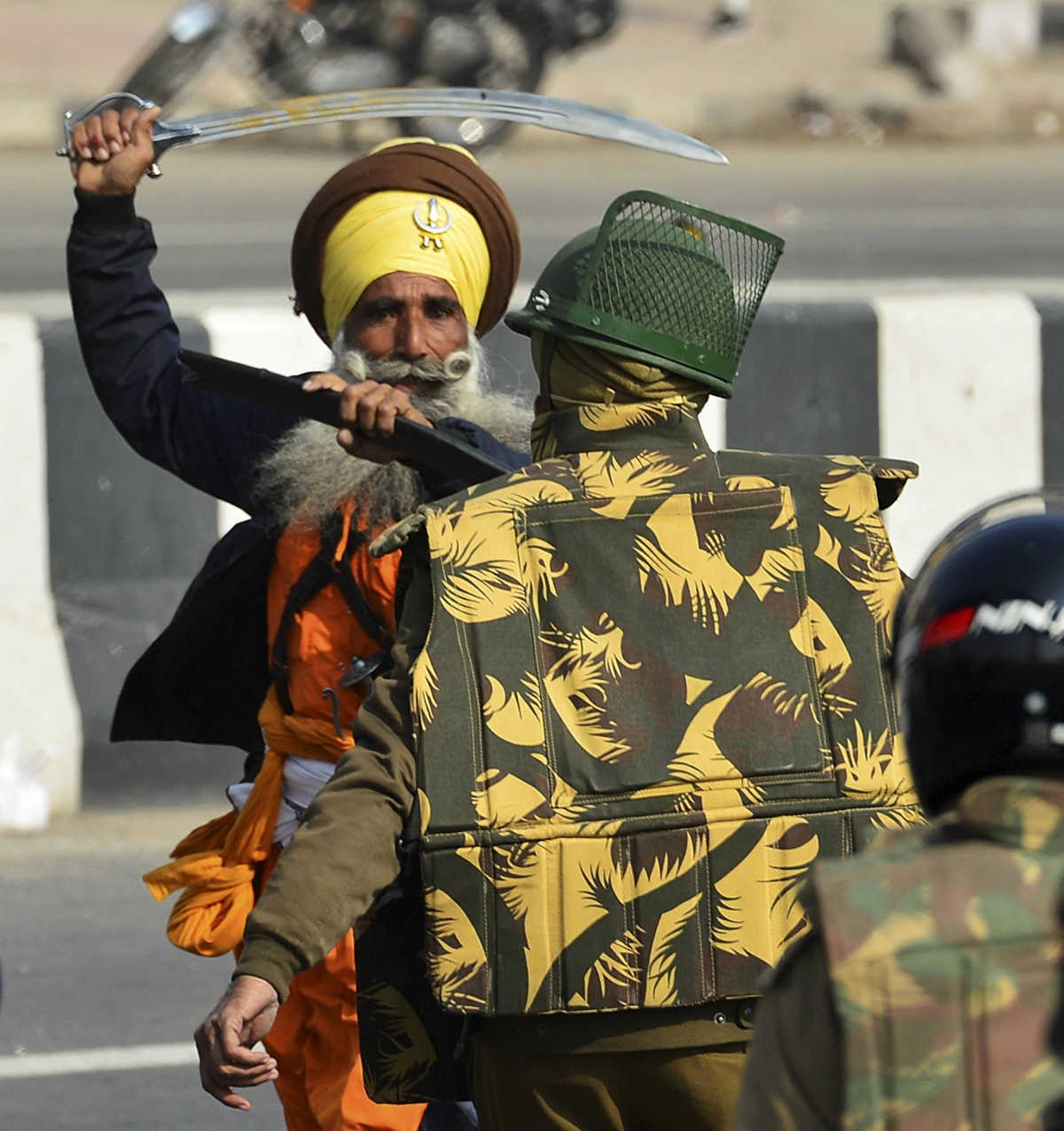 A Nihang protester brandishing a sword at a policeman.