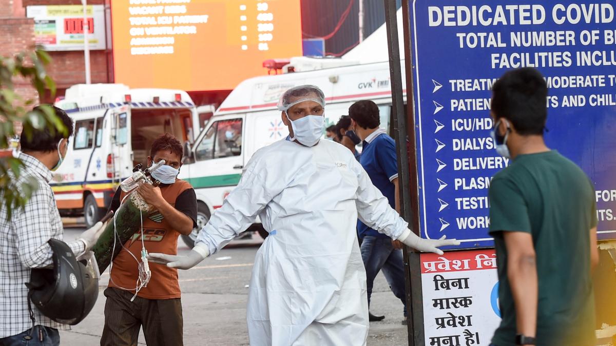 A security person stops people from entering LNJP hospital in Delhi on Saturday owing to non-availability of beds for Covid-19 patients